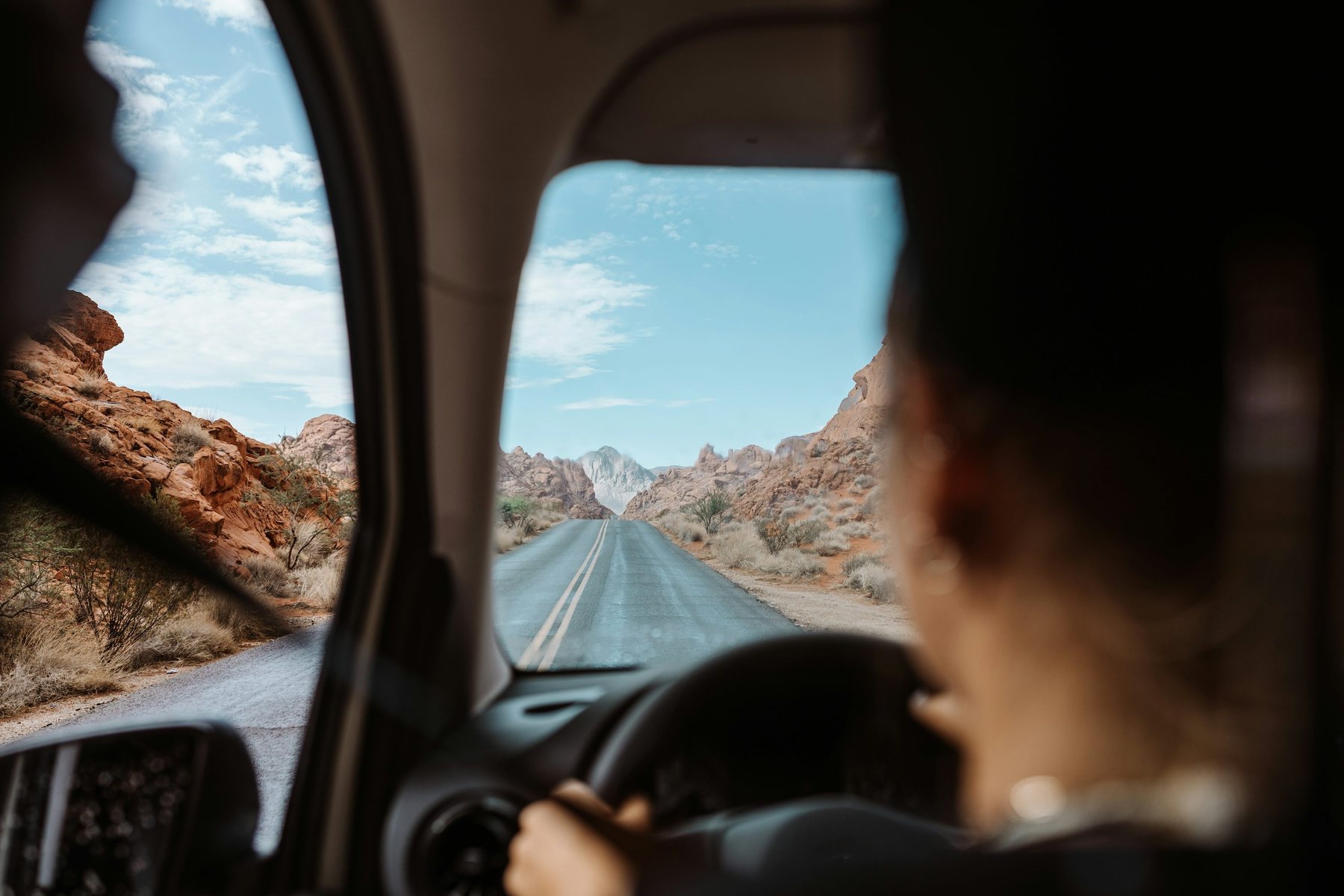 Car driving through a desert highway landscape